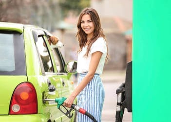 smiling female driver refuelling car with petrol at great UK motorway service station