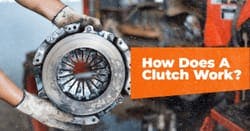 The article title in an orange box beside gloved hands holding a clutch flywheel. 