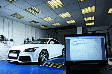 The article title over a car at a garage for engine tuning, and a laptop displaying relevant graphs.
