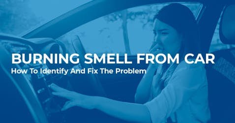 female driver holding her nose and checking car air con system for burning smell