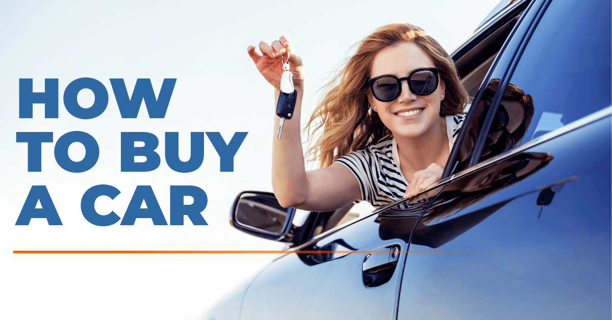 happy female driver leaning out of car window holding keys of brand-new car she just bought