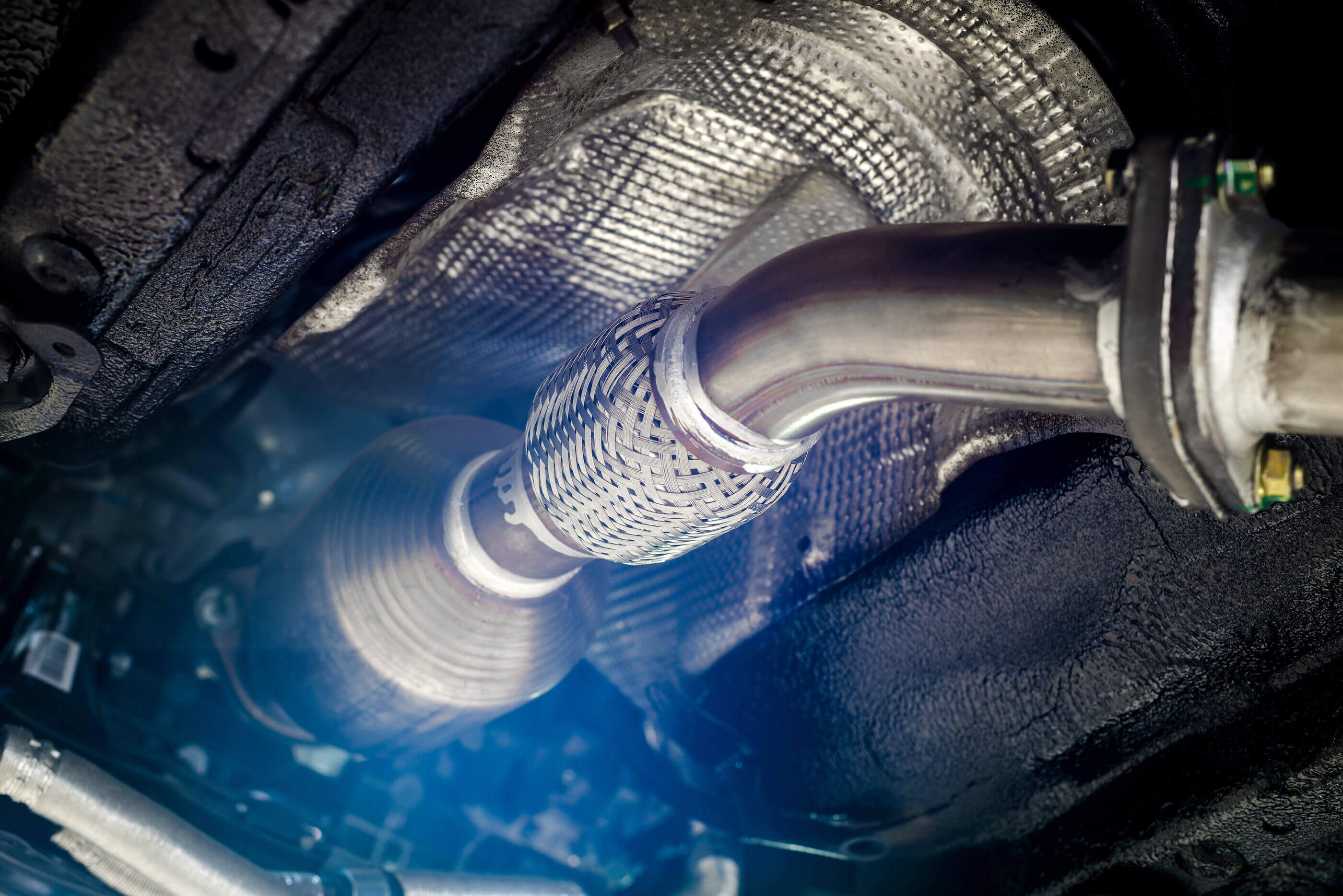 zoomed in image of a catalytic converter on the underside of a vehicle