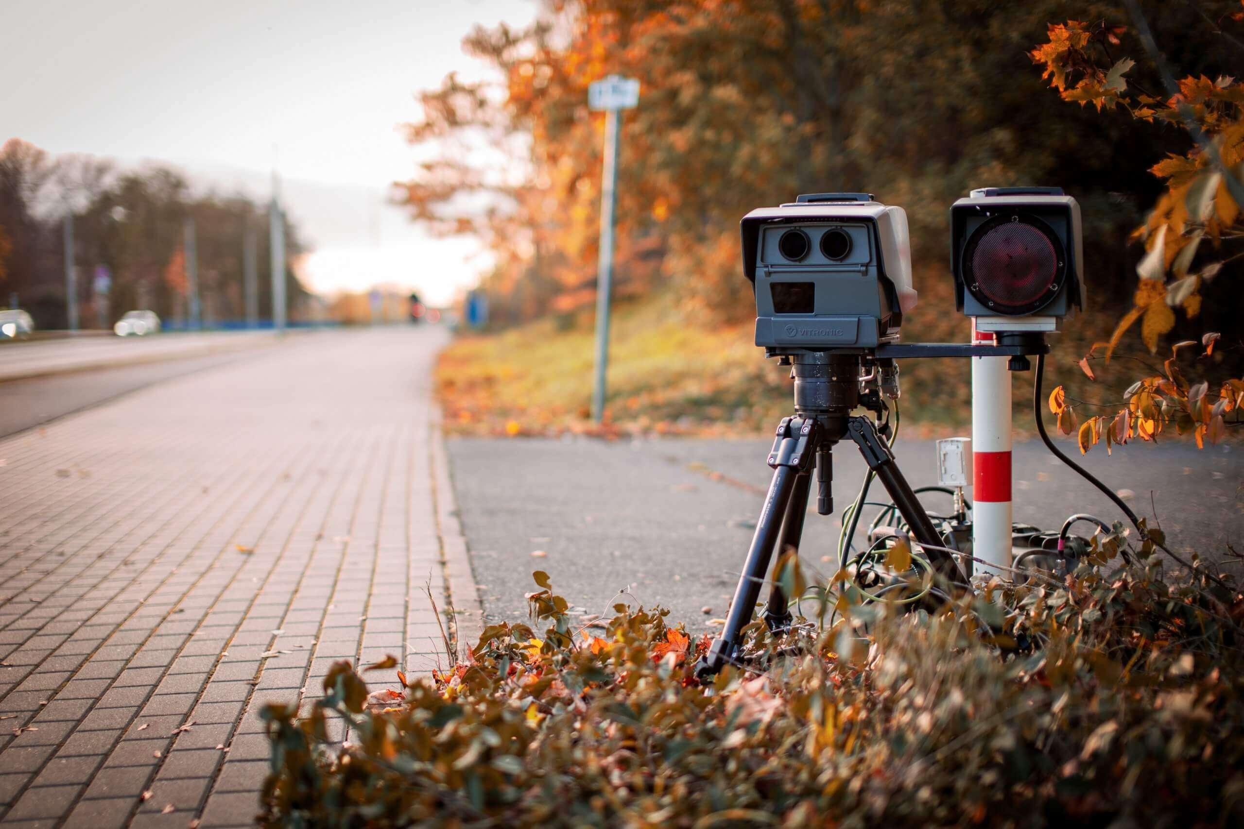 speed camera set up by roadside to catch speeding drivers