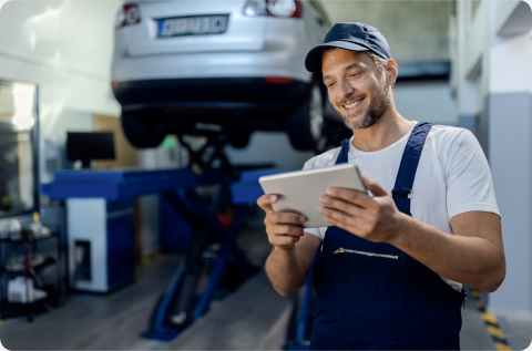 Man with ipad infront of car