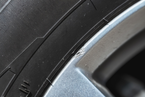 close up shot of alloy wheel fitted to car with minor scratch